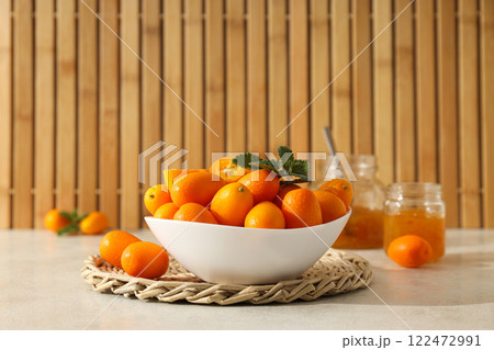 Kumquat in bowl and jars of jam on wooden background 122472991