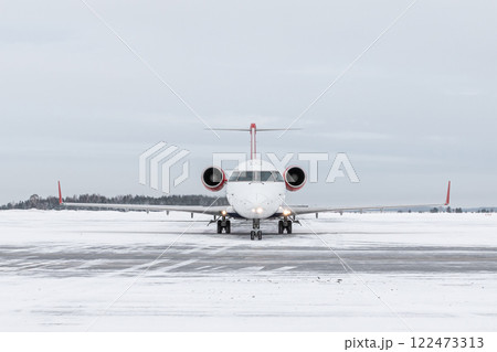 Front view of a passenger regional jet taxiing at winter airport 122473313