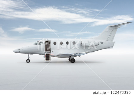 Modern white private jet with an opened gangway door isolated on bright background with sky 122473350