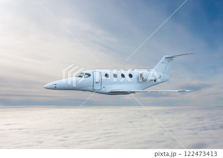 White executive airplane flying in the air above the clouds 122473413