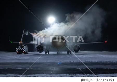 Ground deicing of a passenger aircraft on the night airport apron at winter Ground deicing of a passenger aircraft on the night airport apron at winter 122473454