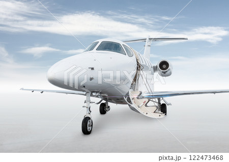 Close-up of the modern white corporate aircraft with an opened gangway door isolated on bright background with sky 122473468