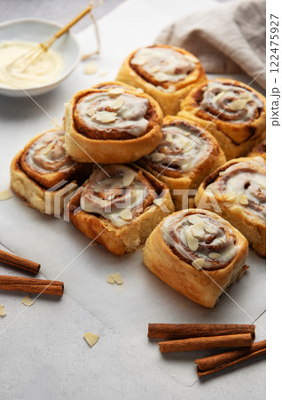 Freshly baked cinnamon rolls topped with icing and almond slivers Freshly baked cinnamon rolls topped with icing and almond slivers 122475927