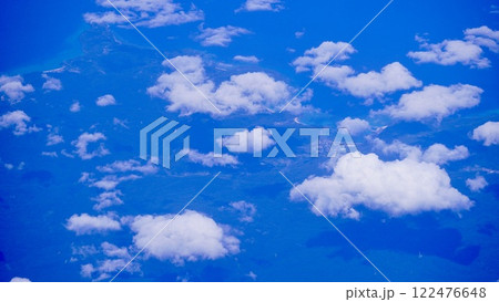 飛行機から見た雲海の合間に見える海岸線 122476648