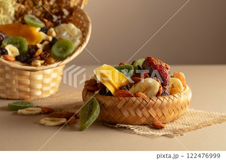 Dried tropical fruits, nuts and raisins on a beige background. Dried tropical fruits, nuts and raisins on a beige background. 122476999