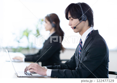 コールセンターで電話を受ける若い男性 コールセンターで電話を受ける若い男性 122477129