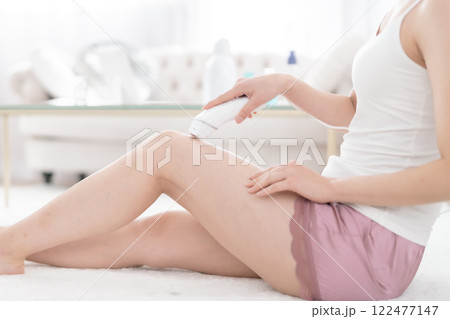 お家で光脱毛をする若い女性　顔無し 122477147