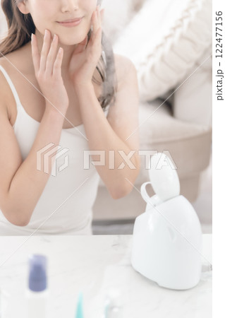 美顔スチーマーを頬に当てる若い女性 顔無し 美顔スチーマーを頬に当てる若い女性 顔無し 122477156