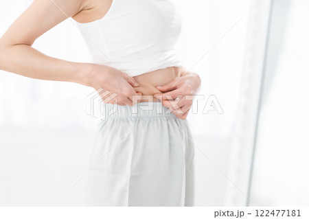 ウエストお肉をつまむ若い女性 ウエストお肉をつまむ若い女性 122477181