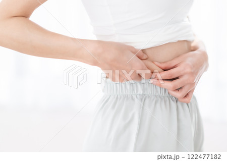 ウエストお肉をつまむ若い女性 ウエストお肉をつまむ若い女性 122477182