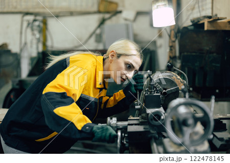 caucasian women worker working in heavy metal industry factory with steel part lathe machine caucasian women worker working in heavy metal industry factory with steel part lathe machine 122478145