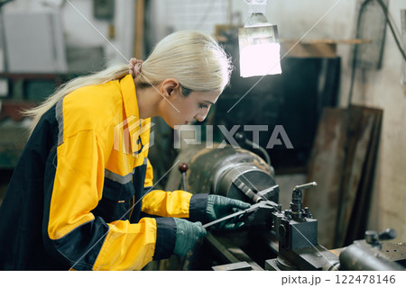female worker using vernier caliper measuring metal part in lathe machine in heavy metal workshop female worker using vernier caliper measuring metal part in lathe machine in heavy metal workshop 122478146