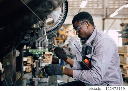 african black male worker working in heavy metal industry factory punching stamping steel machine african black male worker working in heavy metal industry factory punching stamping steel machine 122478169
