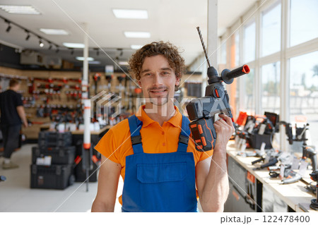 Workman standing with electric power drill manual tool Workman standing with electric power drill manual tool 122478400