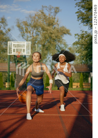 Female basketball players running with ball ready to pass into basket 122478469