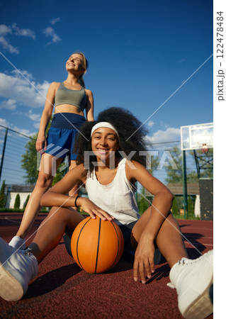 Two attractive multicultural female basketball player taking rest 122478484