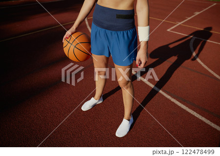 Crop view on basketball ball in hand of young girl player Crop view on basketball ball in hand of young girl player 122478499