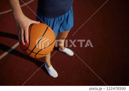 Closeup view on basketball ball in hand of young girl player 122478500