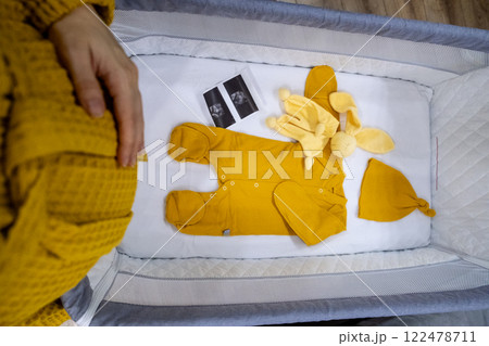 Cozy Baby Crib with Yellow Outfit and Accessories Cozy Baby Crib with Yellow Outfit and Accessories 122478711