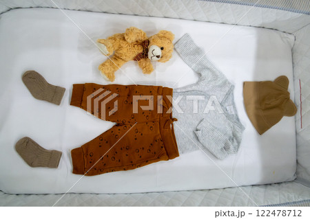 Baby Outfit with Teddy Bear in Crib Baby Outfit with Teddy Bear in Crib 122478712