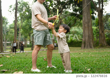 Father and and his little son playing with bubbles in the park Father and and his little son playing with bubbles in the park 122478816