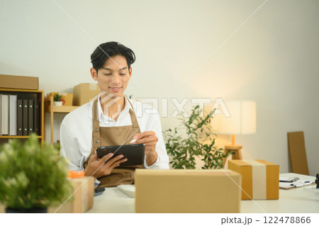 Male entrepreneur works on his digital tablet in a bright and stylish home office Male entrepreneur works on his digital tablet in a bright and stylish home office 122478866