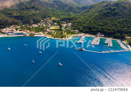 Scenic aerial view many yachts boats moored at Croatian bay harbor shore blue turquoise clear water at bright summer sunny day. Top above Mediterranean sea marina. Boat vessel charter service 122479068