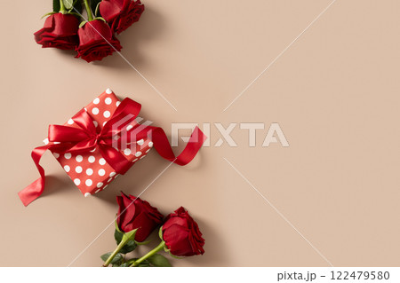 Valentine's day romantic gift and bouquet of red roses on beige background. Close up. Greeting card. Valentine's day romantic gift and bouquet of red roses on beige background. Close up. Greeting card. 122479580