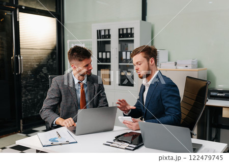 Diverse professionals using a tablet to analysis graph company financial in office. Diverse professionals using a tablet to analysis graph company financial in office. 122479745