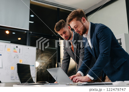 Diverse professionals collaborate on project analysis with financial graphs. Strategic teamwork and insights drive company growth and success. 122479747