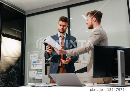 Diverse professionals collaborate on project analysis with financial graphs. Strategic teamwork and insights drive company growth and success. Diverse professionals collaborate on project analysis with financial graphs. Strategic teamwork and insights drive company growth and success. 122479754