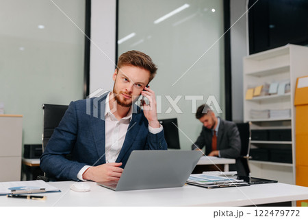 Businessman talking on the phone giving professional consultation to client. 122479772