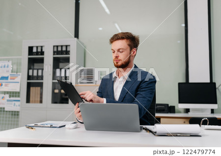 Business man working at office with laptop and documents on desk, financial adviser analyzing data. 122479774