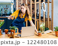 Self-employment. Online classes. Small business concept Professional young Asian female gardener making vlog session on plants pots arrangement class with laptop and phone camera at home. 122480108
