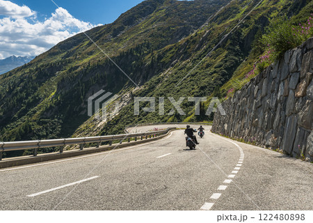 Two bikers riding on the winding Grimsel Pass road in the Swiss Alps, Canton Valais, Switzerland Two bikers riding on the winding Grimsel Pass road in the Swiss Alps, Canton Valais, Switzerland 122480898
