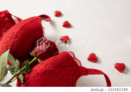 Valentine's day romantic sensual concept. Red lace lingerie, bustier underwear, candy sweets and red roses on white background. Close up. 122481199