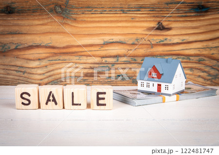 SALE. Wooden alphabet letters and miniature house on a wooden texture background 122481747