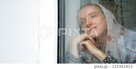 Young girl at the window 122481913