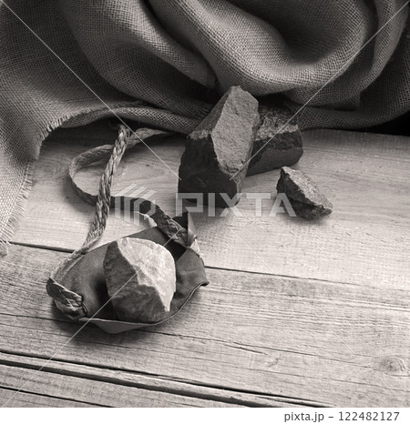 An antique leather sling lies on wooden desk An antique leather sling lies on wooden desk 122482127