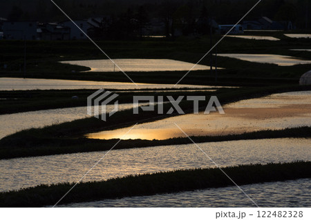 夕日を反射する水田 122482328