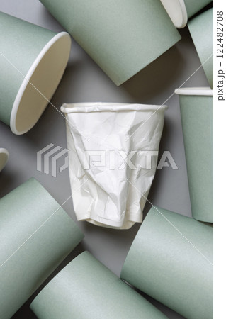 New light green paper cups and crumpled used white one on a gray top view, mockup New light green paper cups and crumpled used white one on a gray top view, mockup 122482708