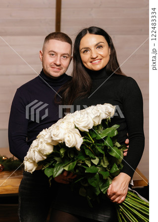Happy couple holding a large bouquet of white roses 122483334