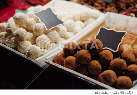 Two trays of chocolate and white desserts sit side by side 122485107