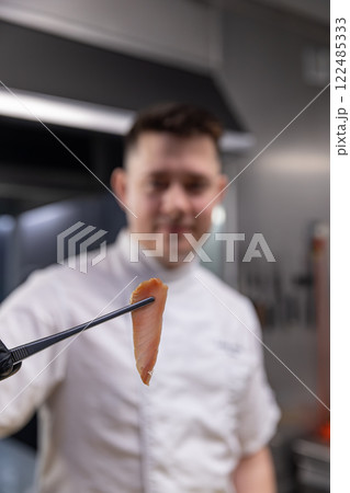 Chef showing a perfect slice of smoked fish 122485333