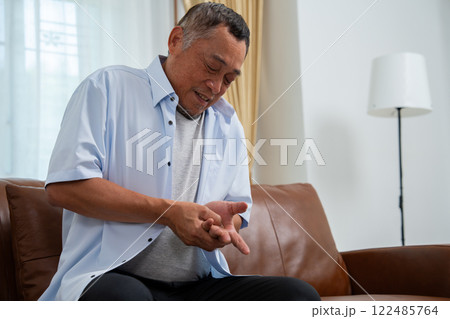 Elderly Asian male patients suffer from numbing pain in hands from rheumatoid arthritis. Senior men massage his hand with wrist pain. Concept of joint pain, rheumatoid arthritis, and hand problems. Elderly Asian male patients suffer from numbing pain in hands from rheumatoid arthritis. Senior men massage his hand with wrist pain. Concept of joint pain, rheumatoid arthritis, and hand problems. 122485764