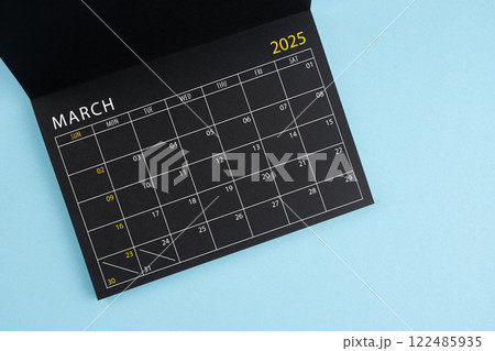 March 2025 Black calendar opening on blue background. 122485935