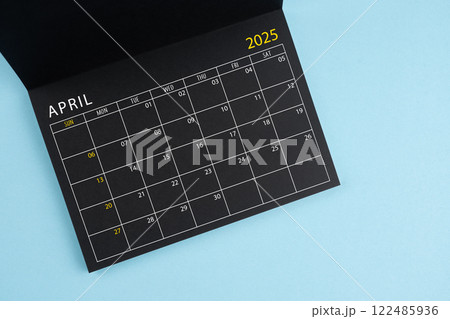 April 2025 Black calendar opening on blue background. 122485936
