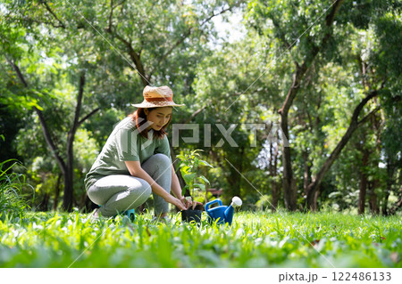 Happy young Asian woman volunteer holding a sapling to plant forests, people and ecology concept, environment Earth Day In the hands of trees growing seedlings, love of nature and care concept Happy young Asian woman volunteer holding a sapling to plant forests, people and ecology concept, environment Earth Day In the hands of trees growing seedlings, love of nature and care concept 122486133