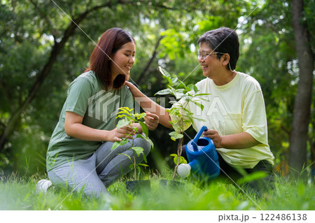 Old Asian Women and daughter join as volunteers for reforestation, earth conservation activities for reduce global warming growth feature and take care nature earth. Environment Concept 122486138