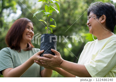 Old Asian Women and daughter join as volunteers for reforestation, earth conservation activities for reduce global warming growth feature and take care nature earth. Environment Concept Old Asian Women and daughter join as volunteers for reforestation, earth conservation activities for reduce global warming growth feature and take care nature earth. Environment Concept 122486140